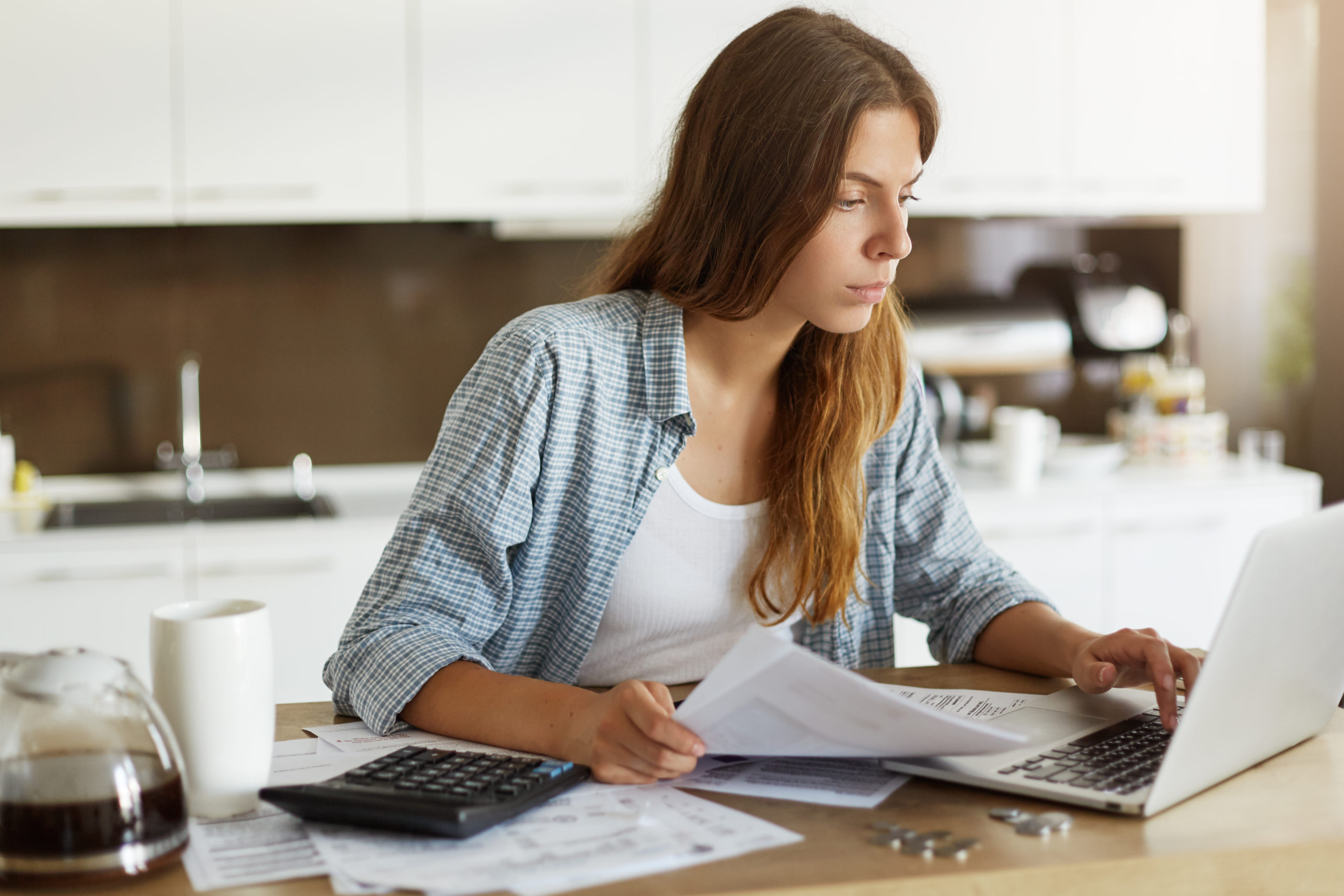 young woman checking her budget doing taxes scaled